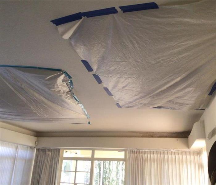 large hole in ceiling covered with tarp
