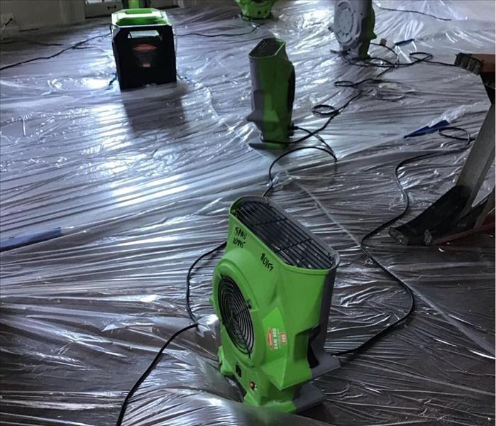 floor with plastic on ground and SERVPRO fans 