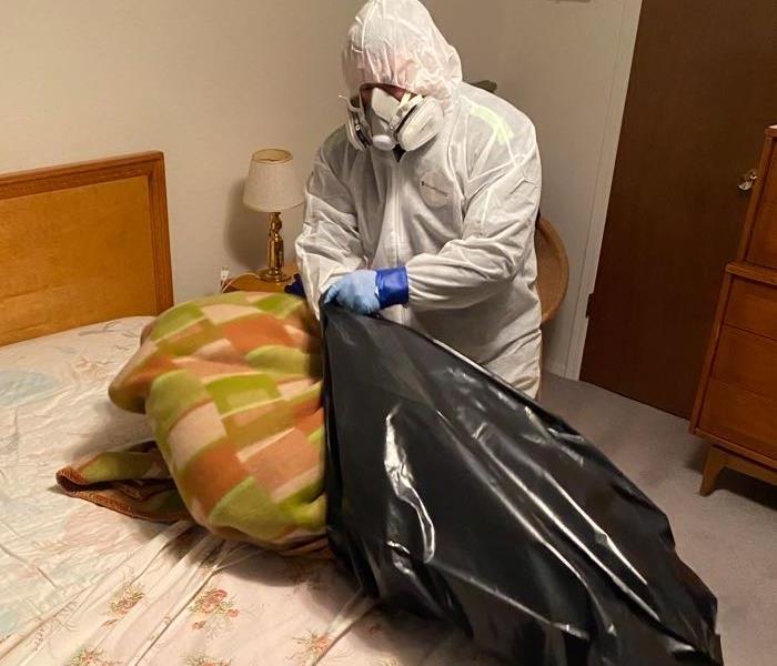 SERVPRO employee in PPE cleaning up biohazard
